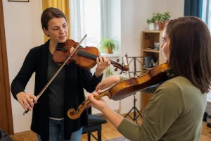 Profesorka violine pokazuje odrasloj početnici položaj gudala